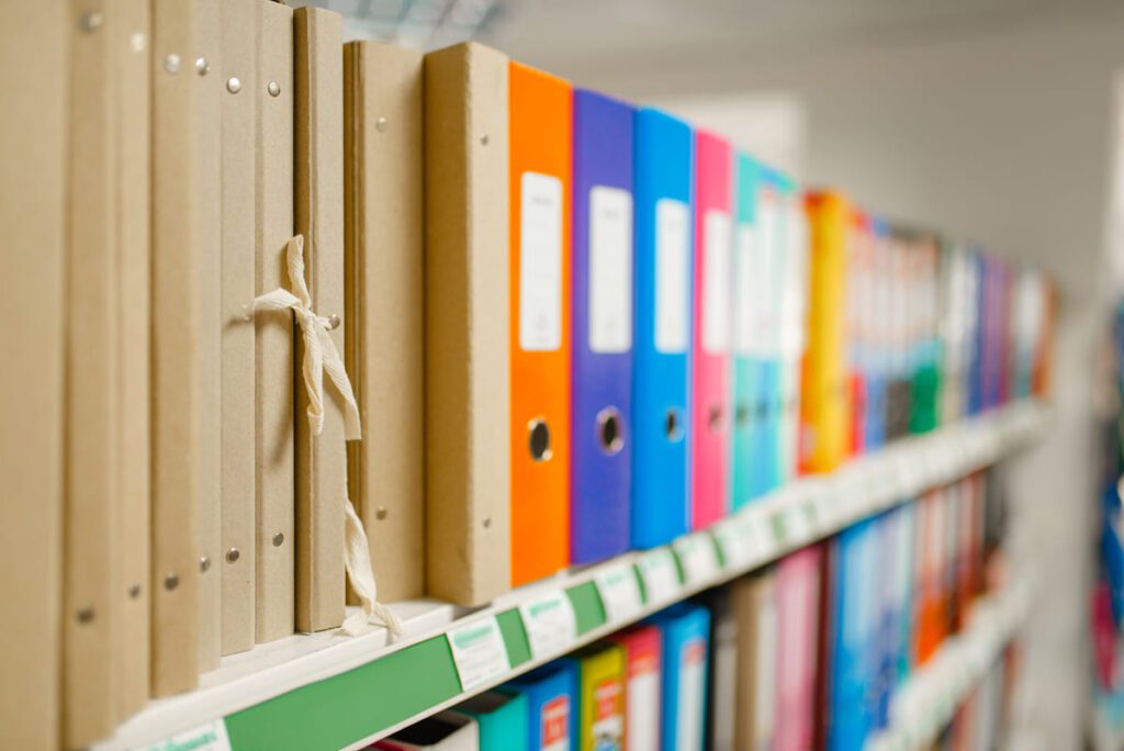 Personal de oficina aplicando técnicas básicas de archivo físico para organizar documentación en carpetas.