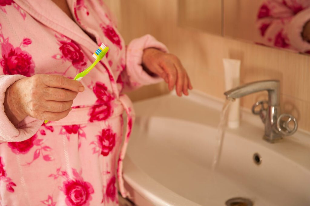 Profesional aplicando protocolos de higiene en personas mayores dependientes para asegurar su salud y bienestar físico.