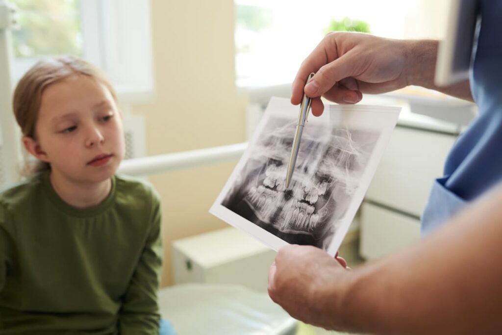 Protección radiológica adecuada para pacientes pediátricos en radiología dental durante la toma.